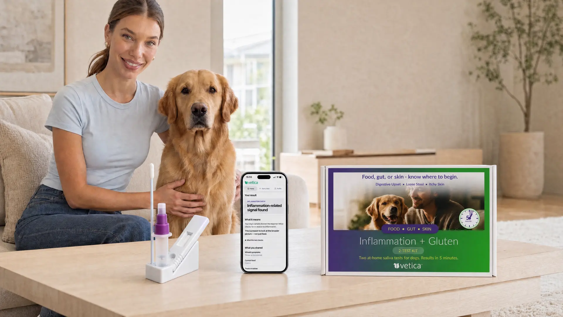 A woman with her golden retriever at home, with a Vetica test, a phone showing a result and the 2-Test Kit box on the table